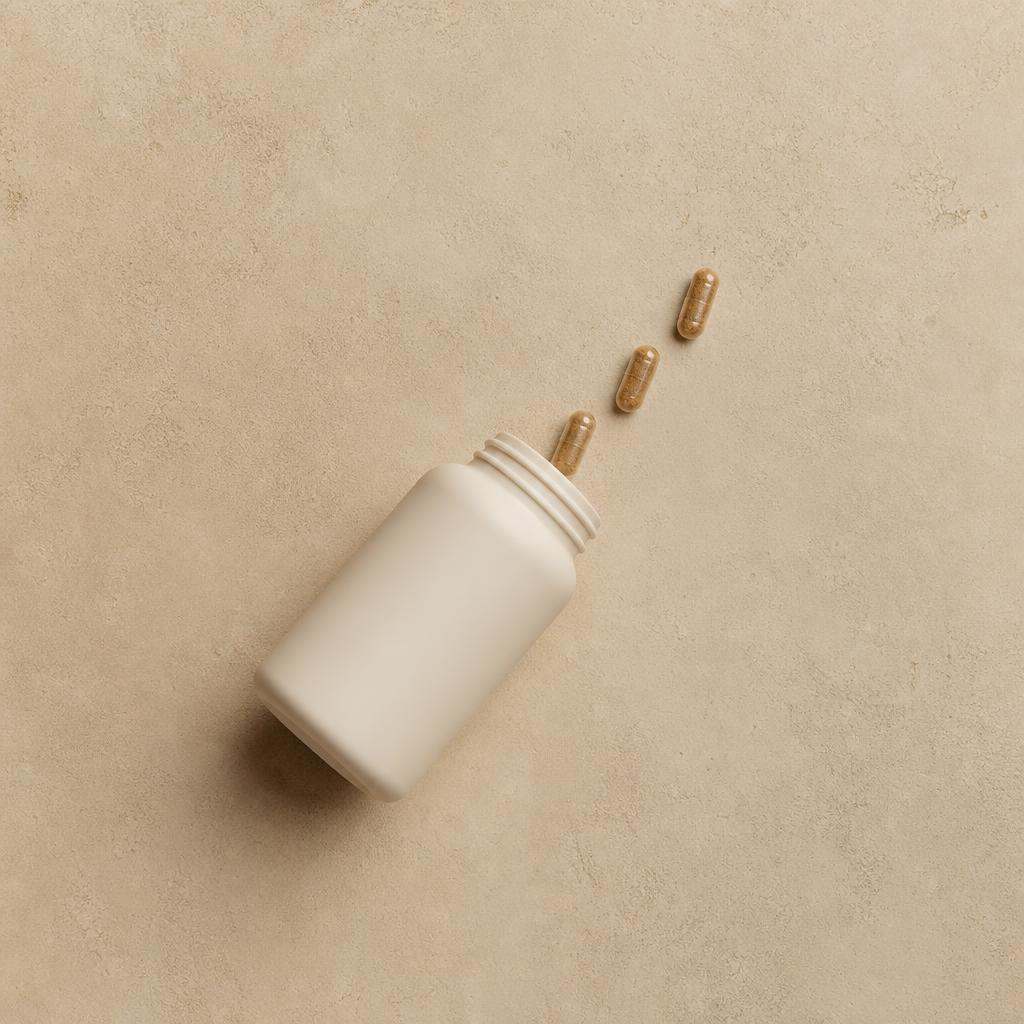 Plant-based supplement bottle and capsules on stone