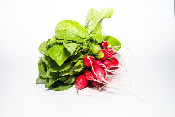 a bunch of radishes with green leaves on a white background