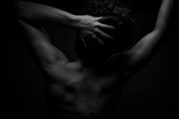 A black and white photo of a naked man