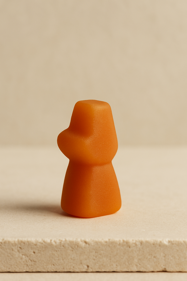 Close-up of a vibrant orange vegan gummies supplement shaped like a figure, showcasing its appealing texture