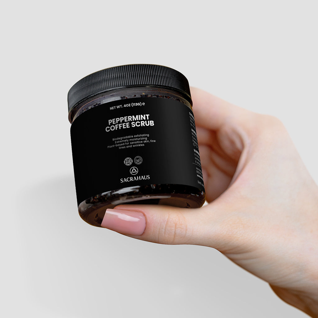 SACRAHAUS Peppermint Coffee Scrub for Sensitive Skin in a jar held by a hand
