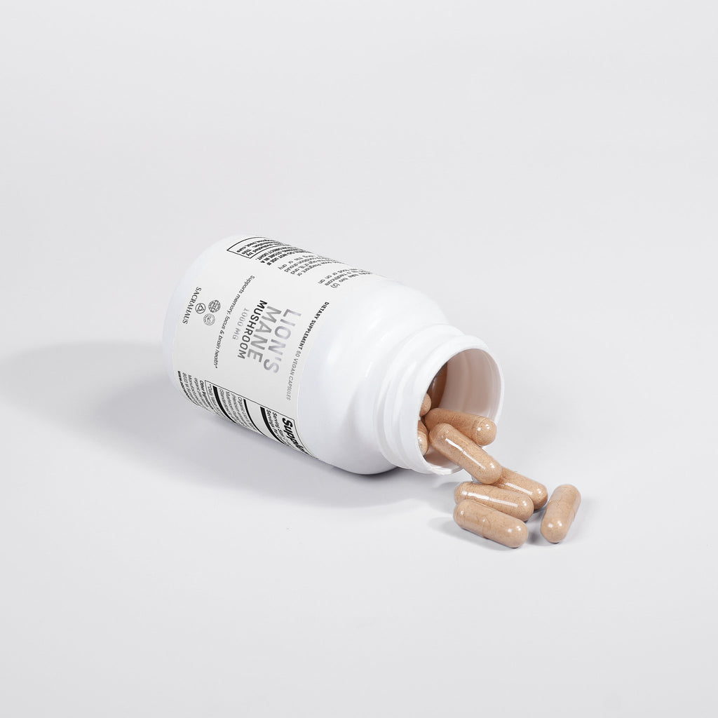 SACRAHAUS lion's mane mushroom supplement capsules spilling from a white bottle