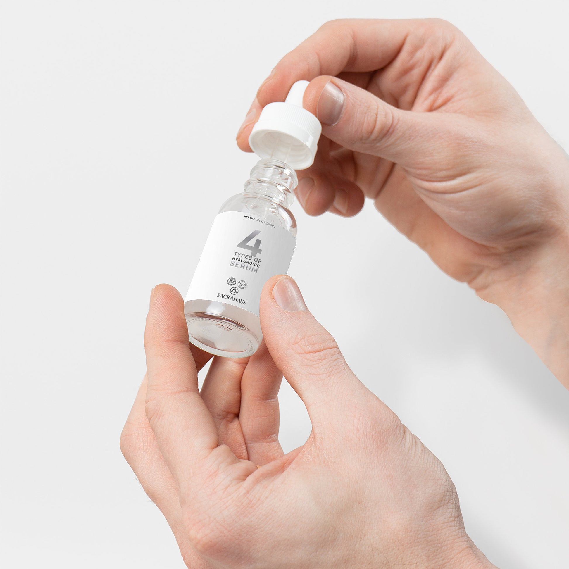 SACRAHAUS vegan hyaluronic acid serum in dropper bottle held by hands for facial care routine
