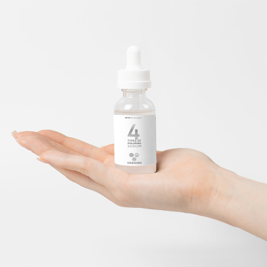 SACRAHAUS vegan hyaluronic acid serum bottle held in a hand, designed for facial care