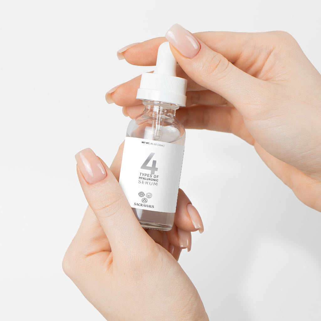SACRAHAUS vegan hyaluronic acid serum in a clear dropper bottle held by hands