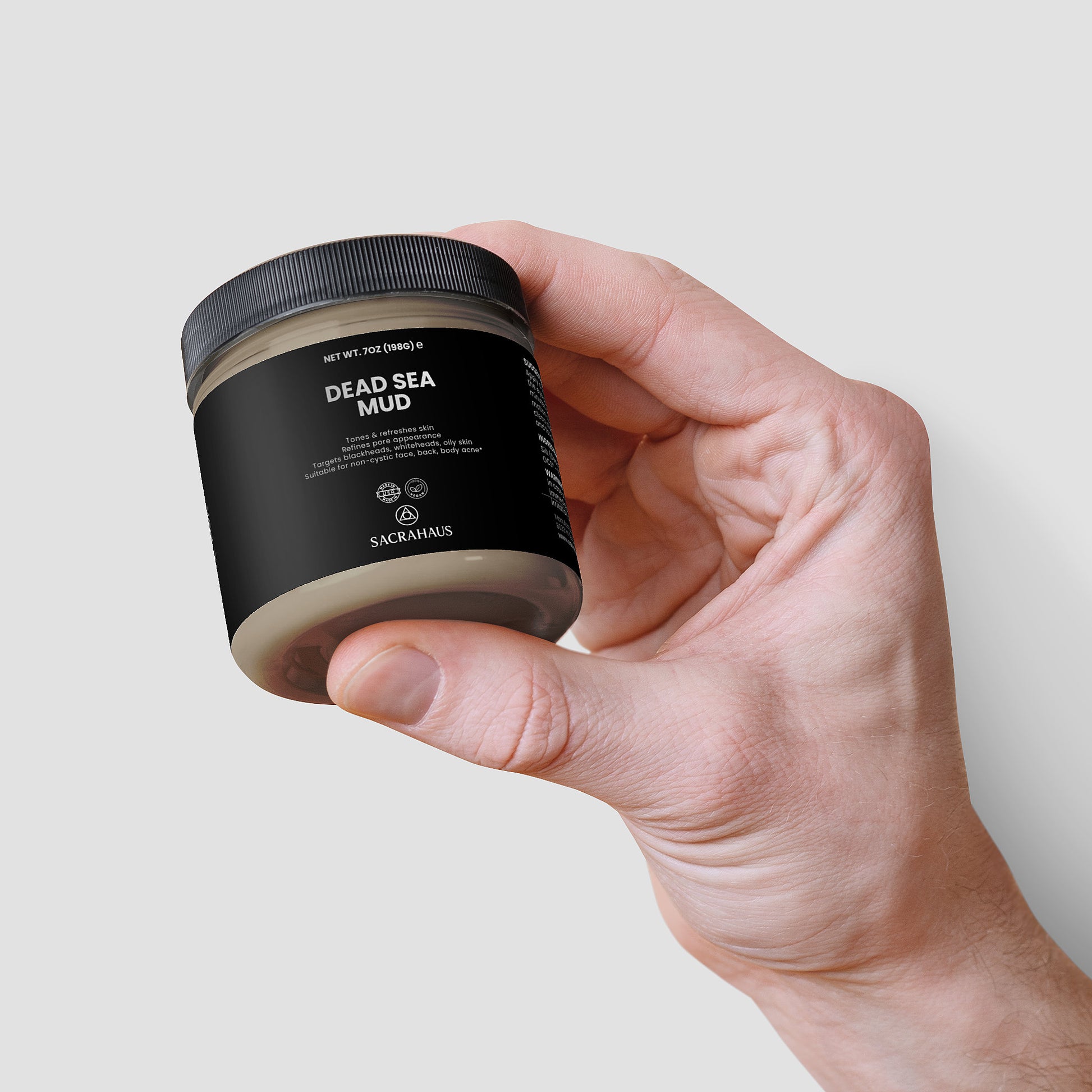 SACRAHAUS Dead Sea mud mask in hand, promoting skin nourishment and hydration