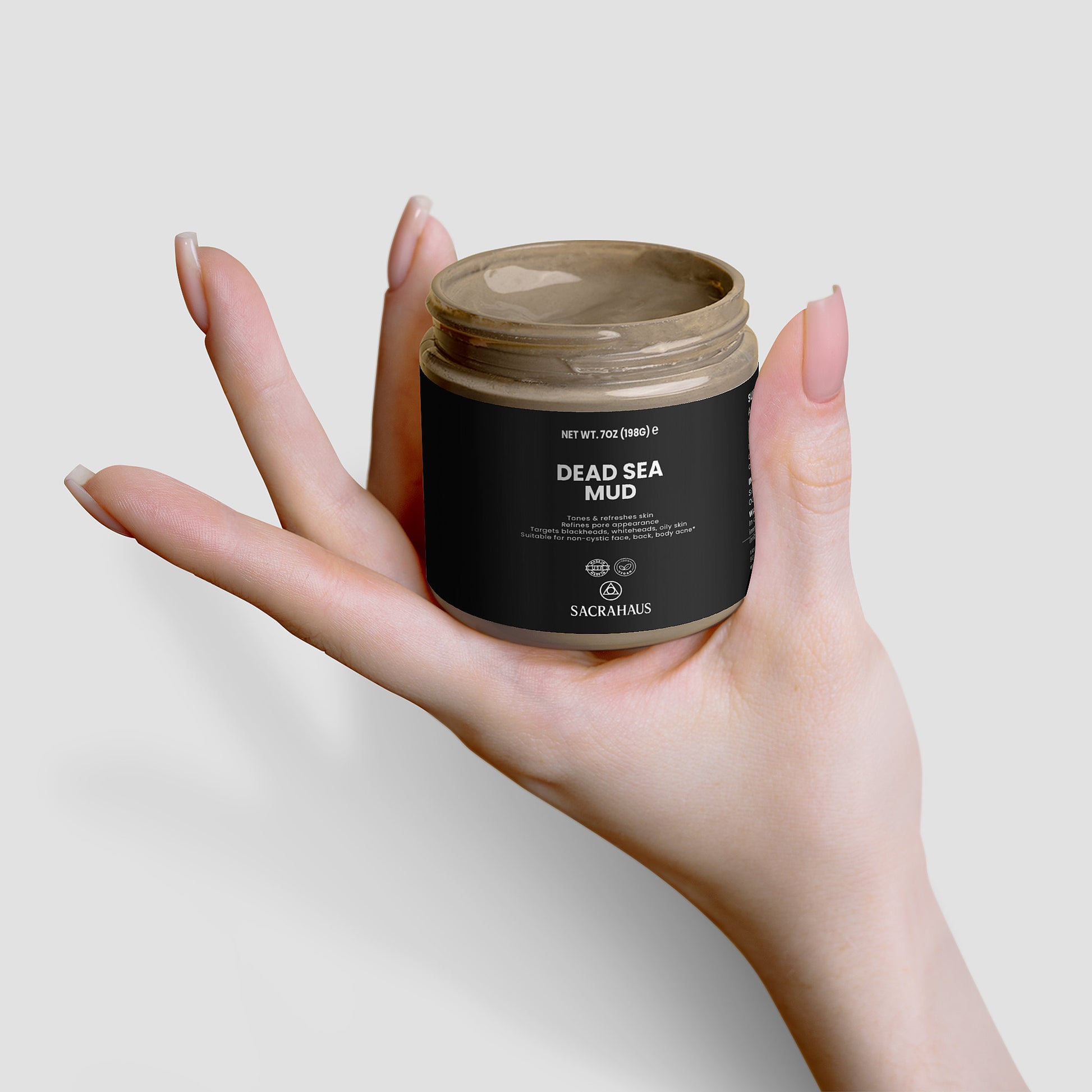 SACRAHAUS Dead Sea mud mask in a hand, showcasing its rich texture and benefits for skin care