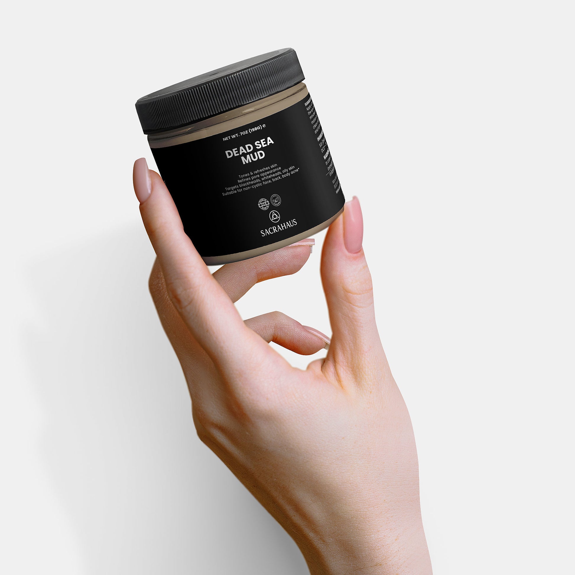 SACRAHAUS Dead Sea mud mask in a sleek jar held in a hand for rejuvenating skin care