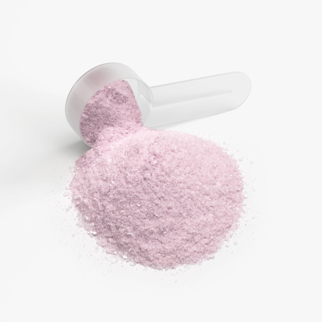 SACRAHAUS lychee hydration powder in a clear scoop showcasing its vibrant pink color