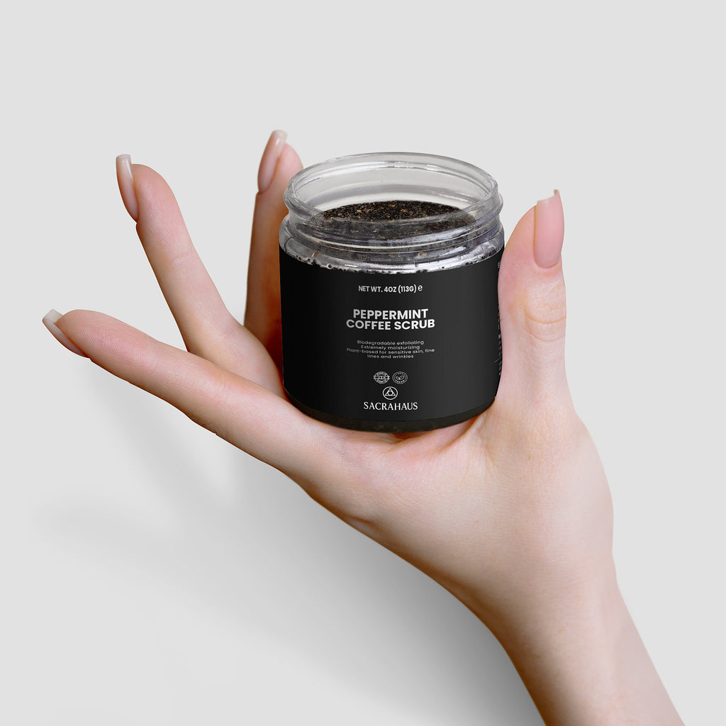 SACRAHAUS Peppermint Coffee Scrub for Sensitive Skin in a Glass Jar Held in a Hand
