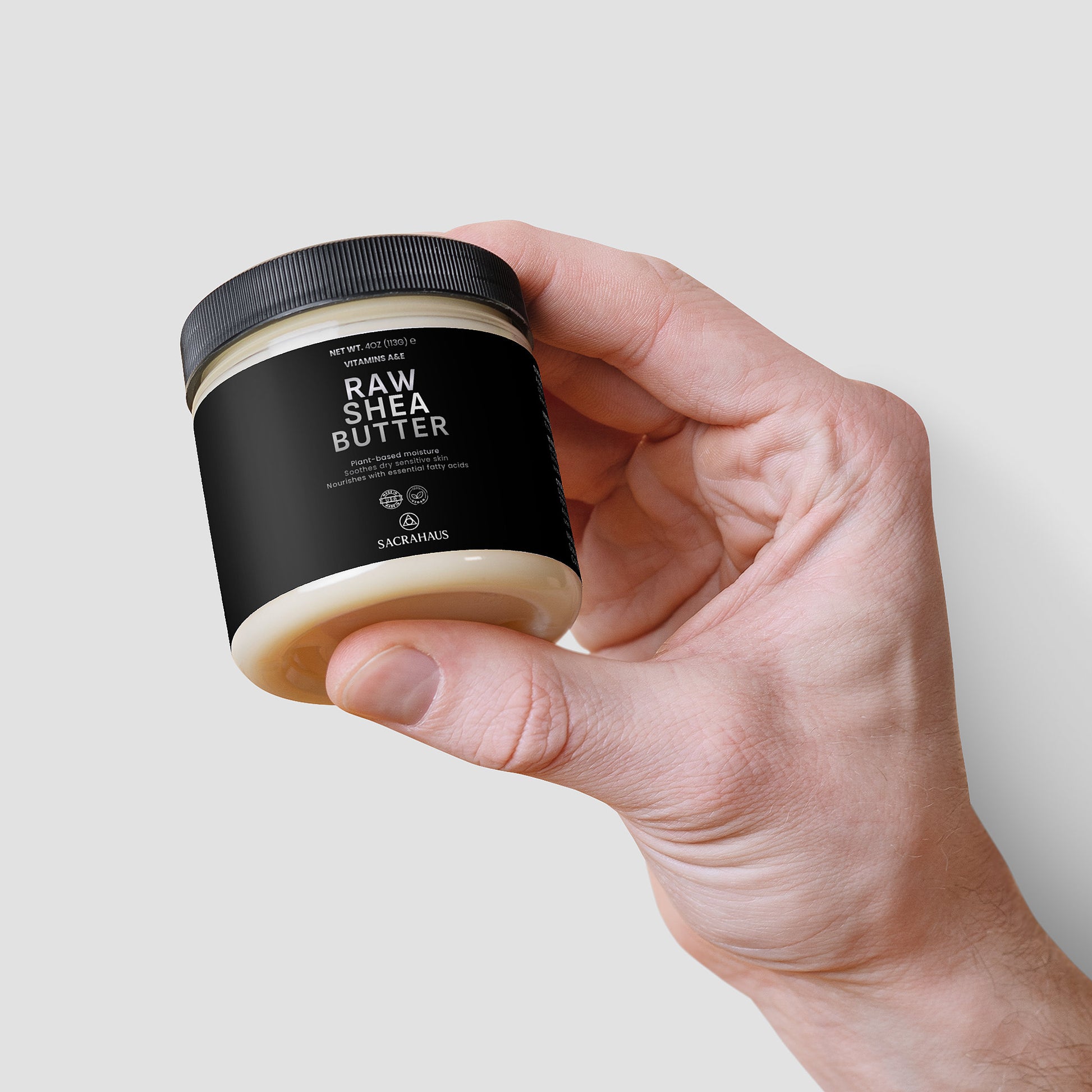 SACRAHAUS Raw Shea Butter for Skin in a jar held by a hand, perfect for moisturizing and nourishing
