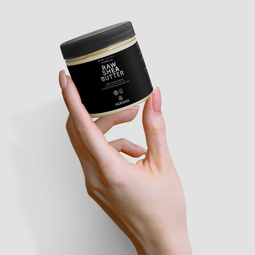 SACRAHAUS raw shea butter for skin in a sleek jar held by a hand, perfect for moisturizing and nourishing skin