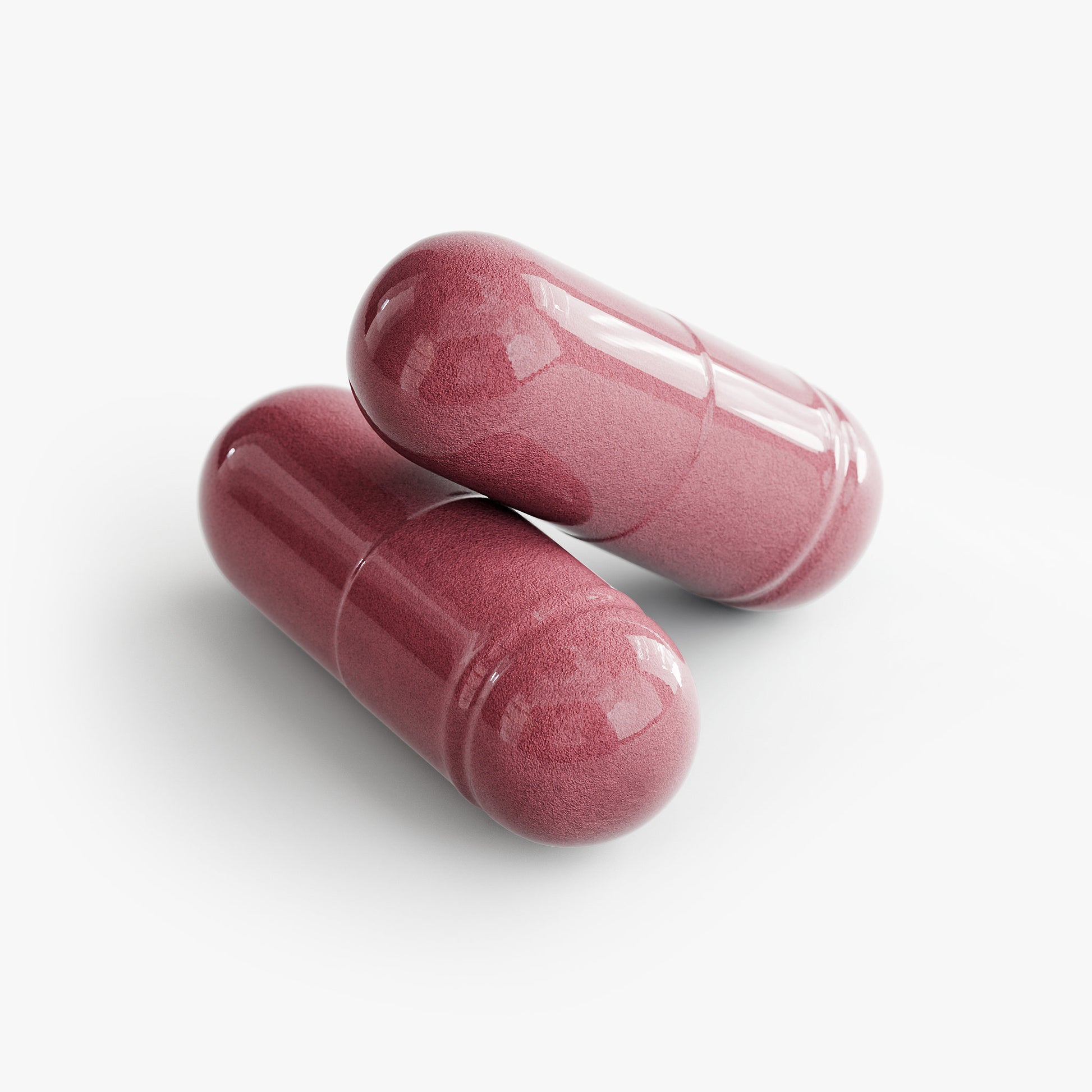 Two pink capsules of SACRAHAUS vegan beet supplement natural extract on white background