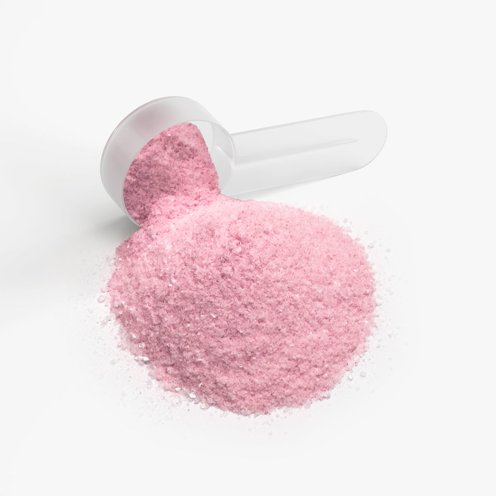 SACRAHAUS vegan energy powder in pink hue with a clear measuring scoop for easy serving