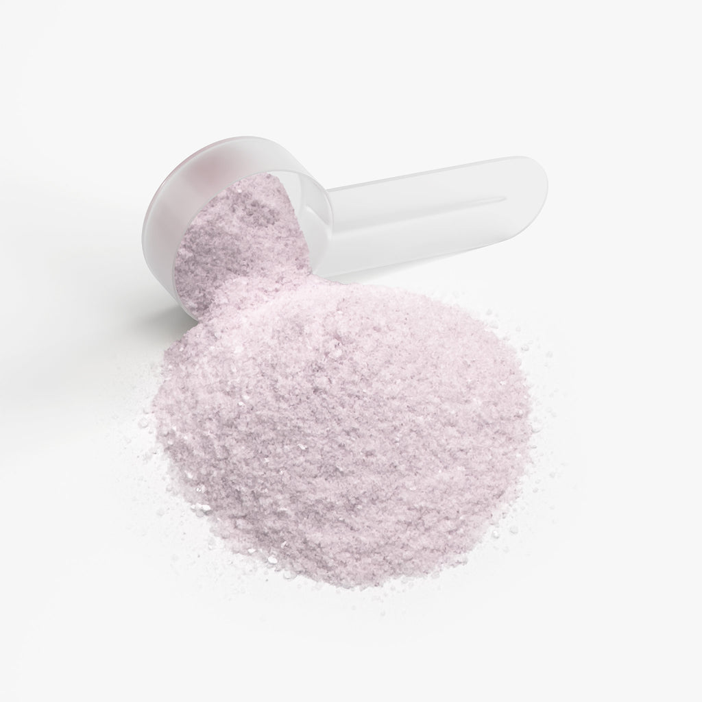 SACRAHAUS vegan energy powder in a clear scoop with pink granules for pre-workout energy boost