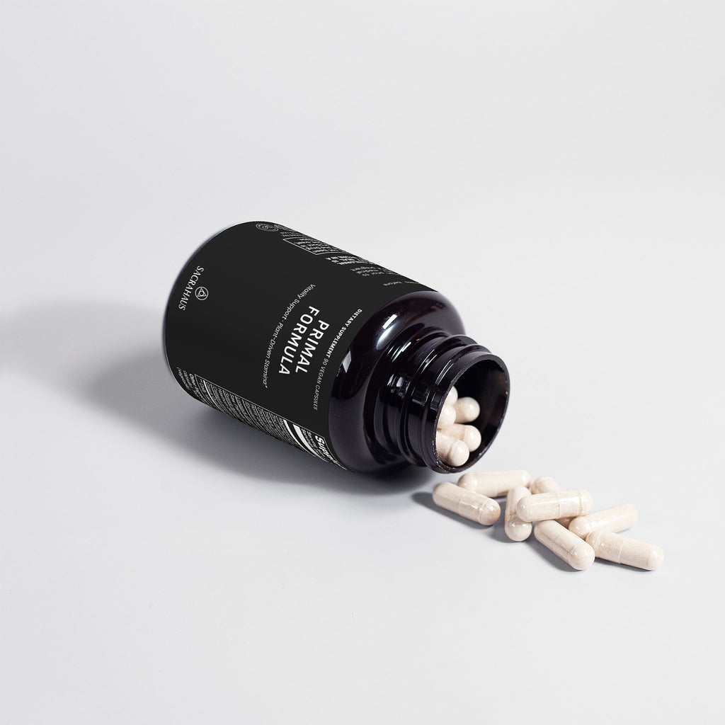SACRAHAUS vegan supplements for men Primal Formula specialty supplement capsules spilling from black bottle