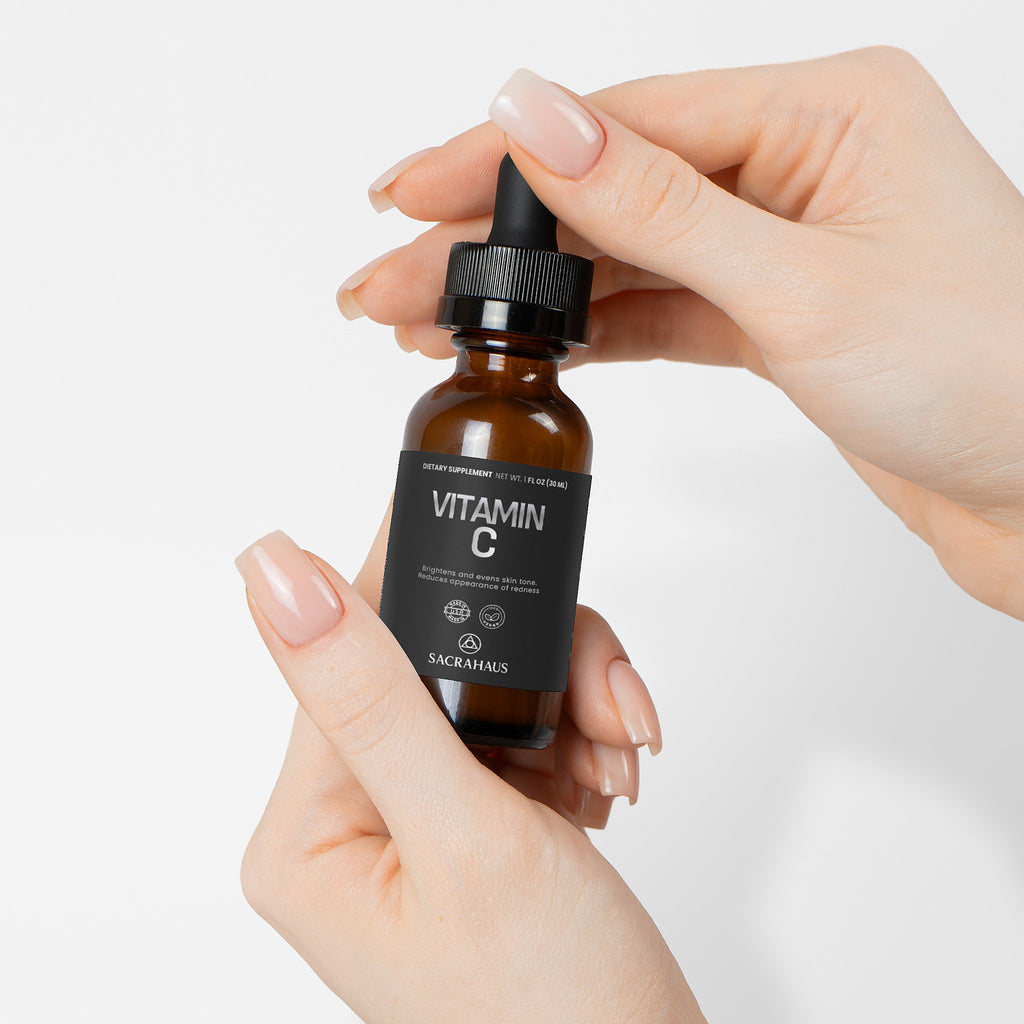 SACRAHAUS vegan vitamin C serum in a dropper bottle held between hands for radiant skin care