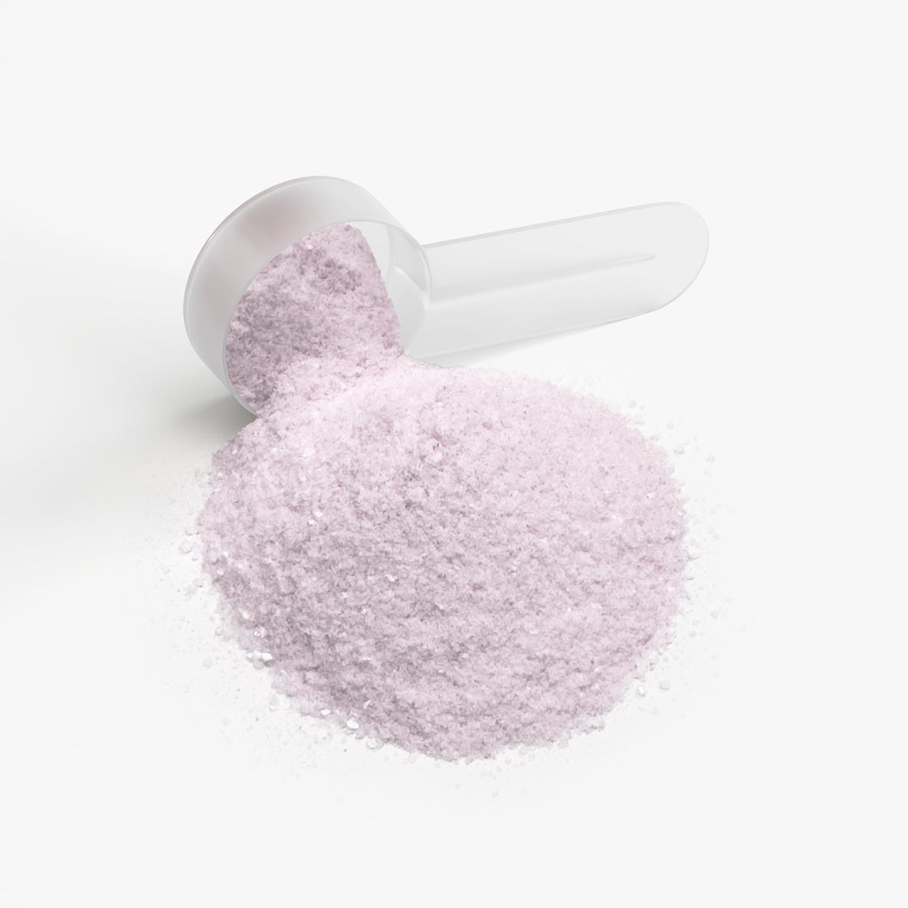 SACRAHAUS yuzu energy powder in a scoop, featuring a fine pink texture for pre-workout energy boost