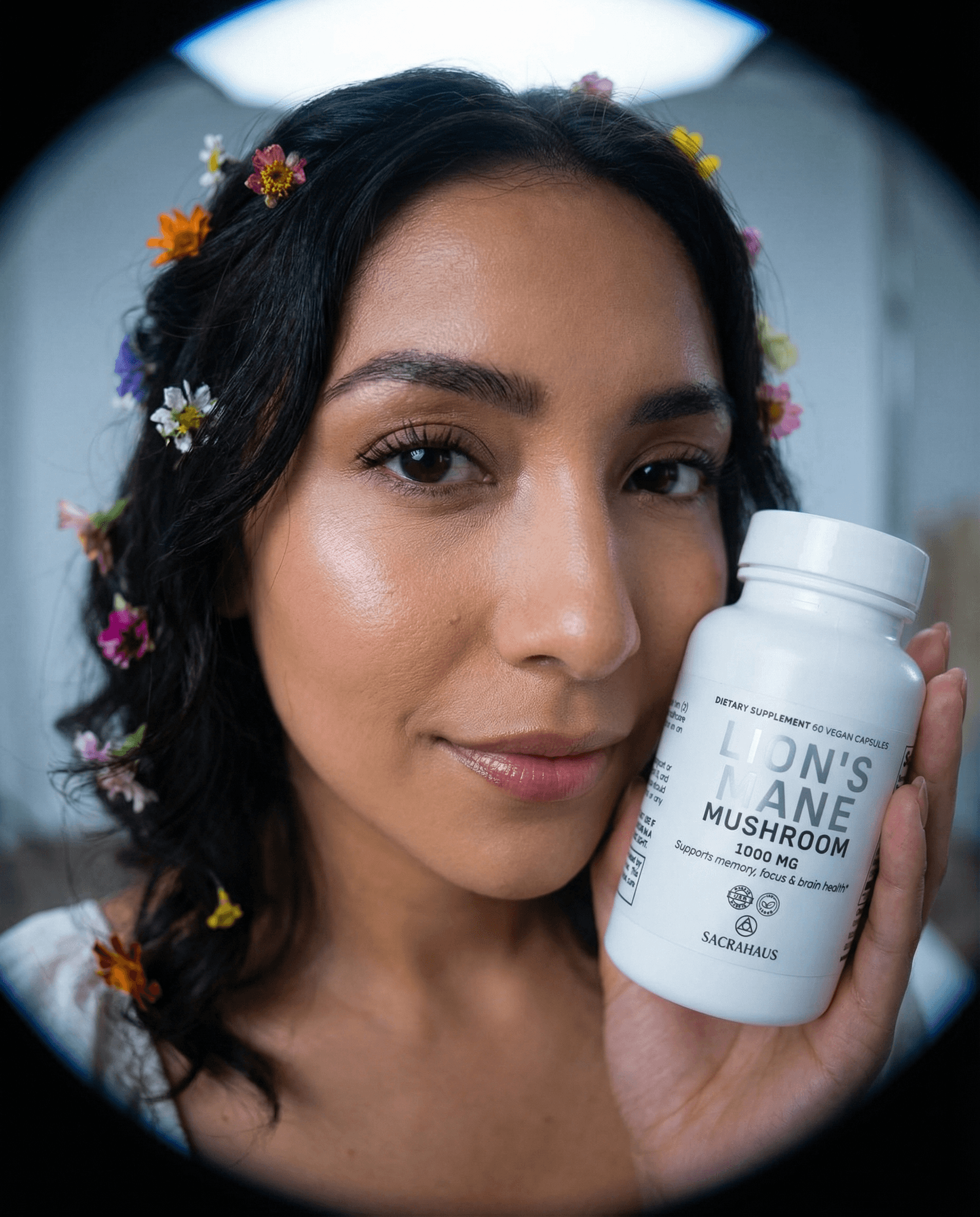 SACRAHAUS lion's mane mushroom supplement bottle held by a woman with flower crown for natural wellness