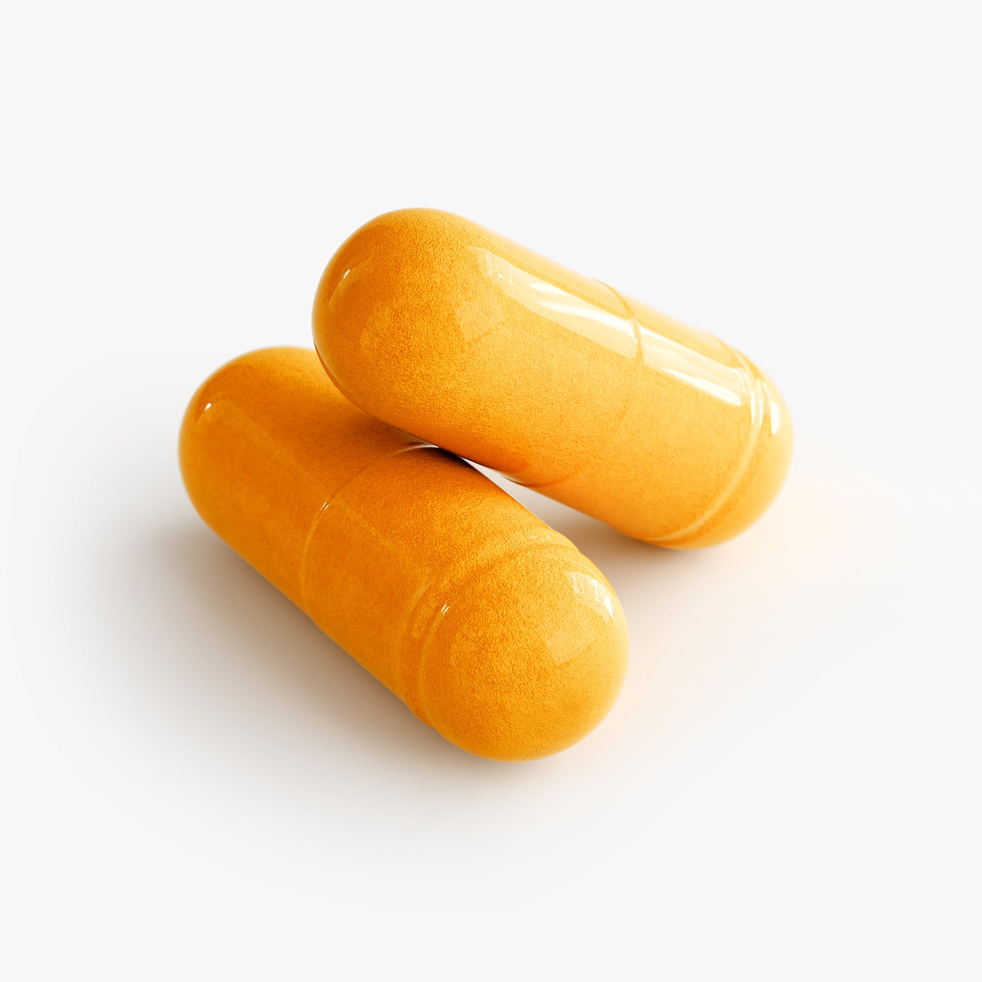 Close-up of two yellow capsules of SACRAHAUS vegan CoQ10 supplement on white background
